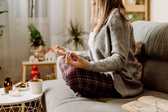 focus sur les mains et jambes d'une femme qui médite