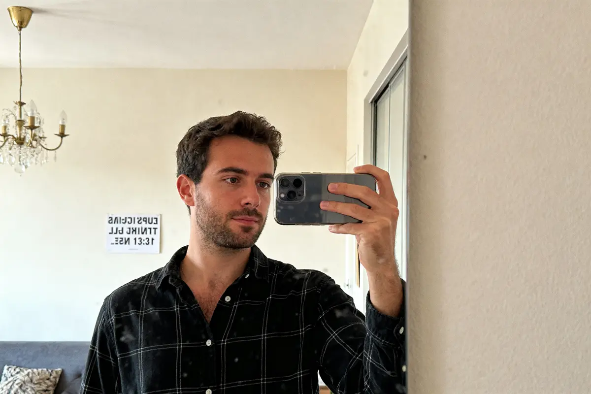 Homme prenant un selfie avec un téléphone devant une heure miroir à 13h31